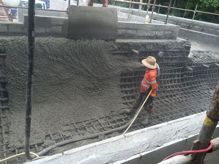 Worker levelling wet concrete on a residential slab