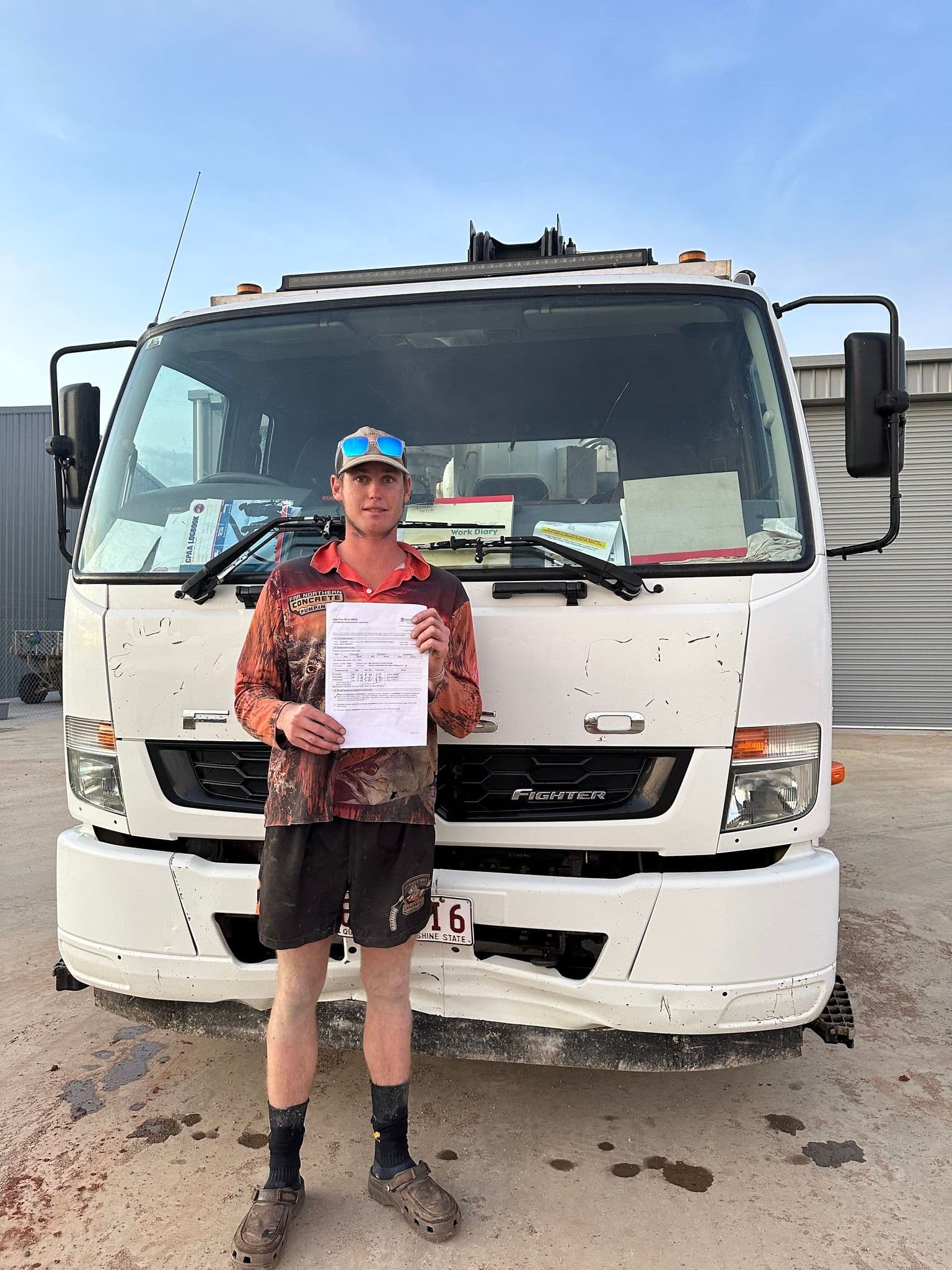 Man Holding Paper Stands in Front of a White Truck — Far Northern Concrete Pumping in Cairns, QLD