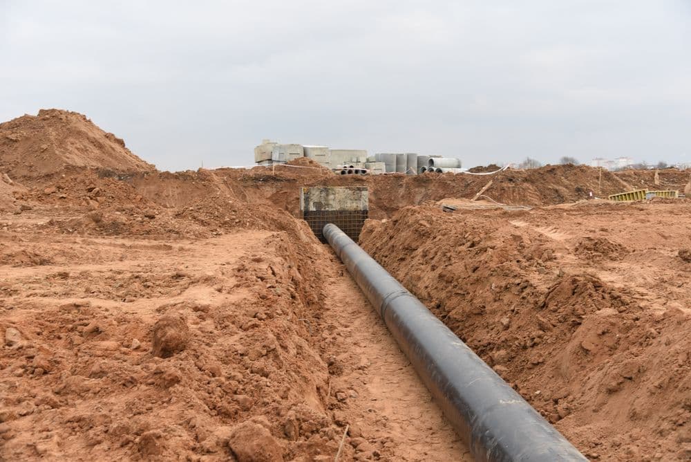 Black Pipe in an Open Trench, Surrounded by Brown Dirt — Far Northern Concrete Pumping in Cape York, QLD