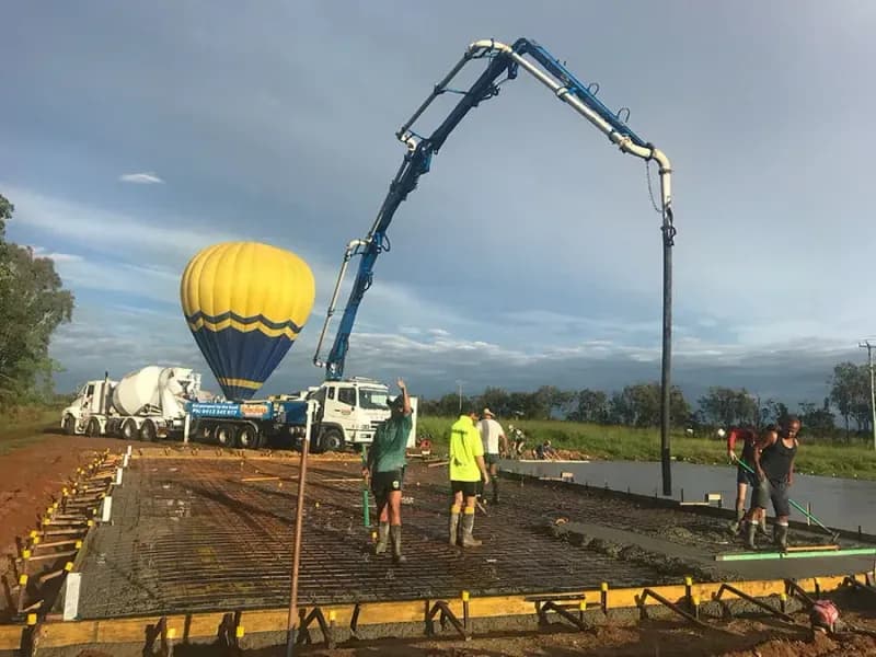 Construction Site With Concrete Being Poured Workers, and Cement Mixer — Far Northern Concrete Pumping in Mareeba, QLD